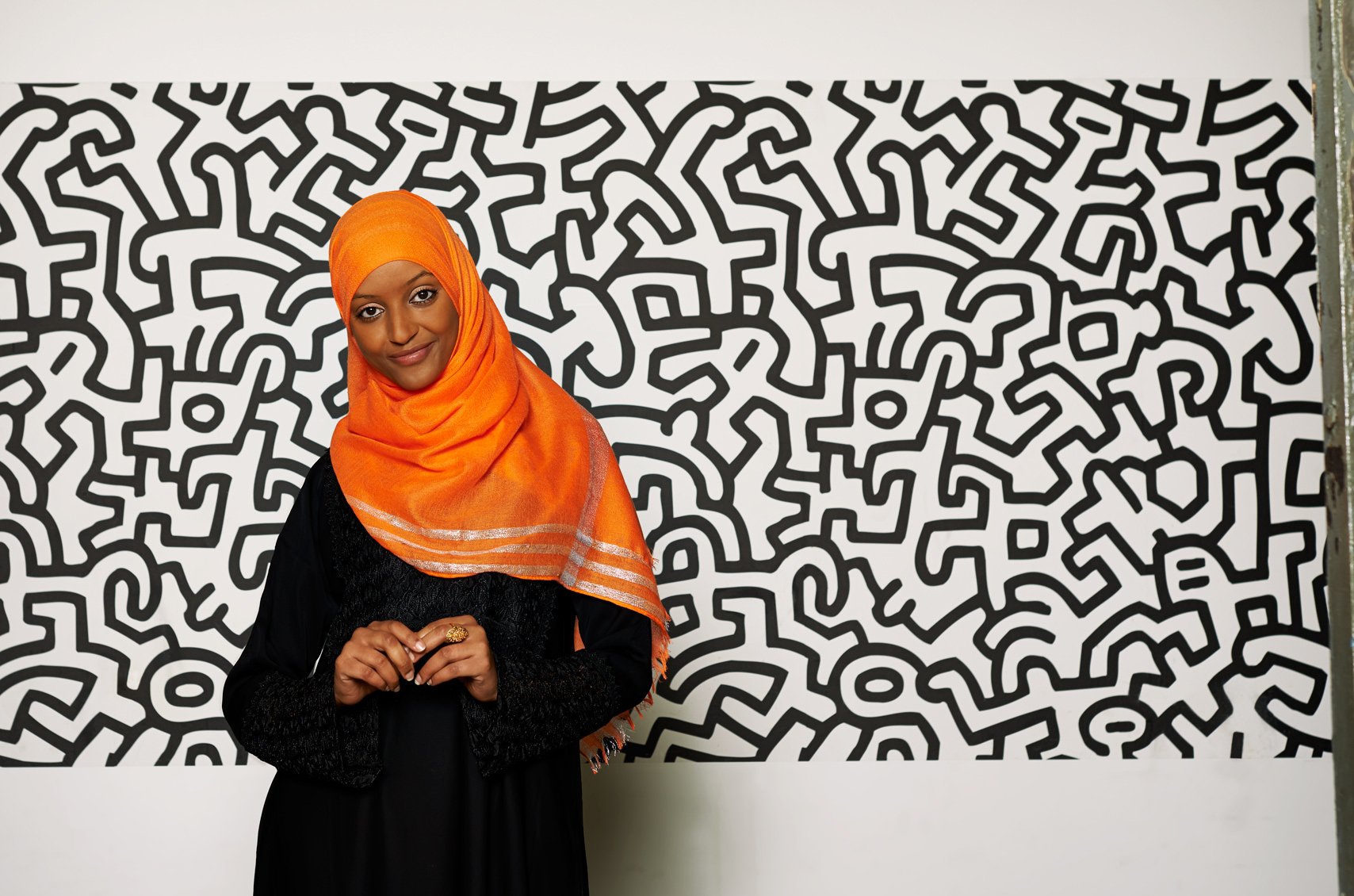 Beautiful Muslim woman in a orange hijab with Warhol backdrop