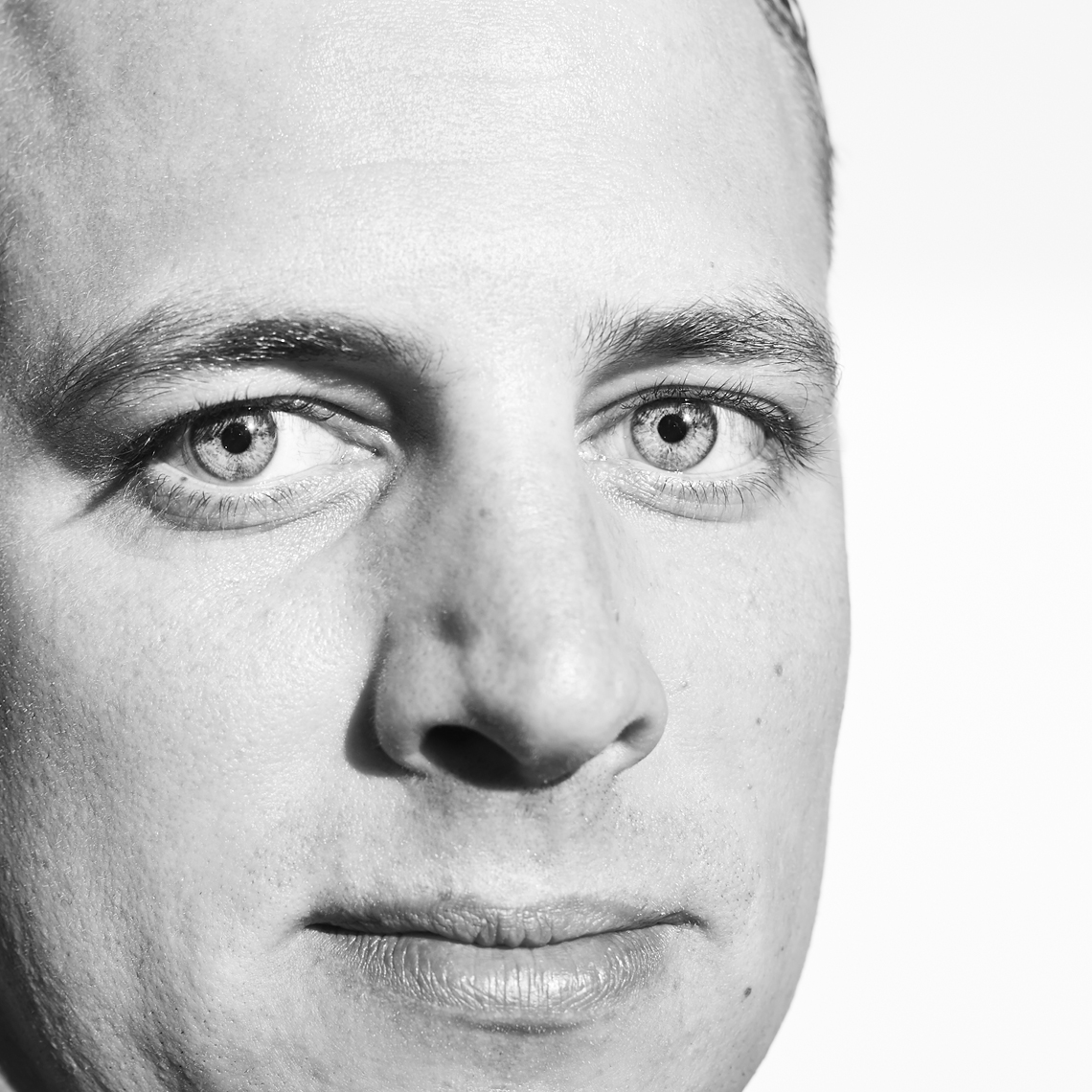 Super tight headshot of blue eyed white man with intense look_black&white