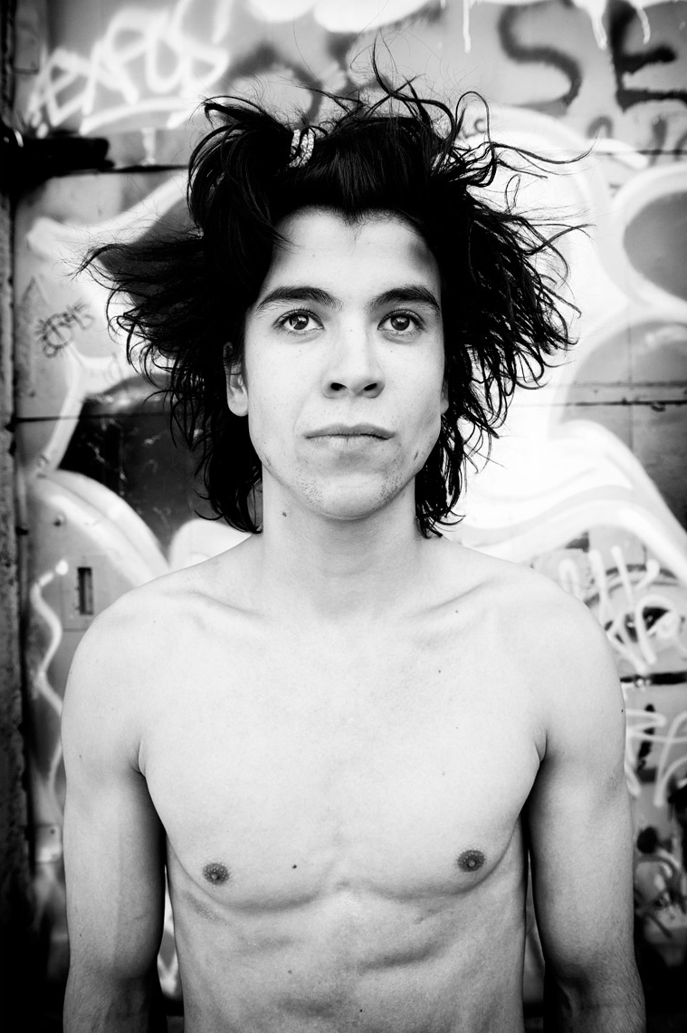 Young topless white man with messy hair and graffiti background_black and white Tmon Vincent